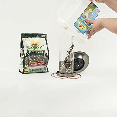 Pouring bird seed into a feeder with Wagner's Gourmet package nearby.