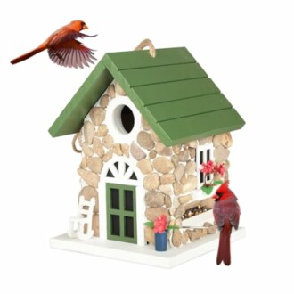 Decorative stone birdhouse with two red cardinals.