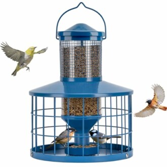 Blue bird feeder with three birds flying around it.