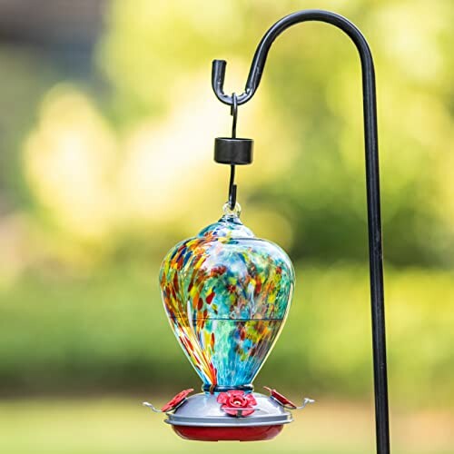 Colorful glass hummingbird feeder hanging outdoors