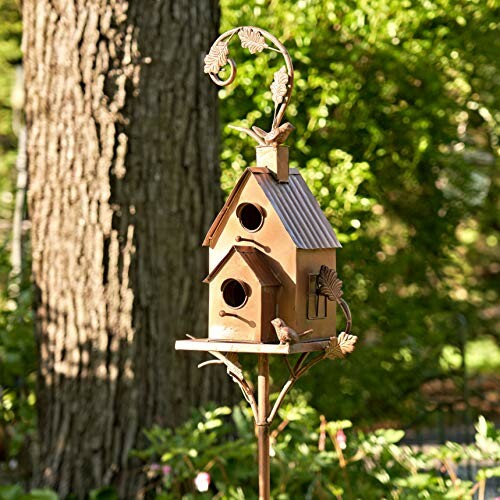 Decorative metal birdhouse in garden setting