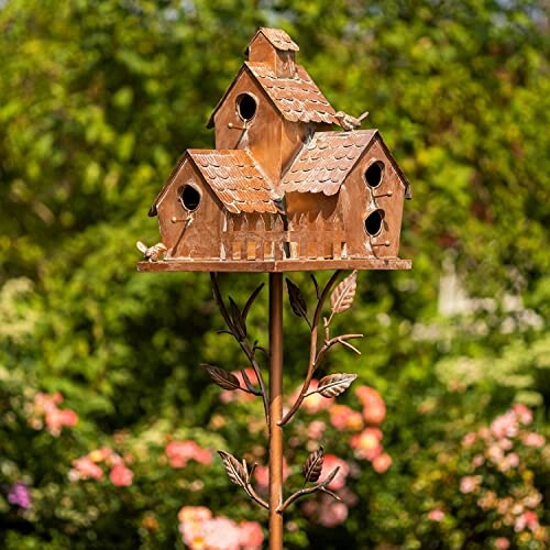 Decorative birdhouse on a pole in a garden setting