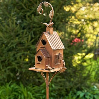 Decorative metal birdhouse on a stand with a leafy design.