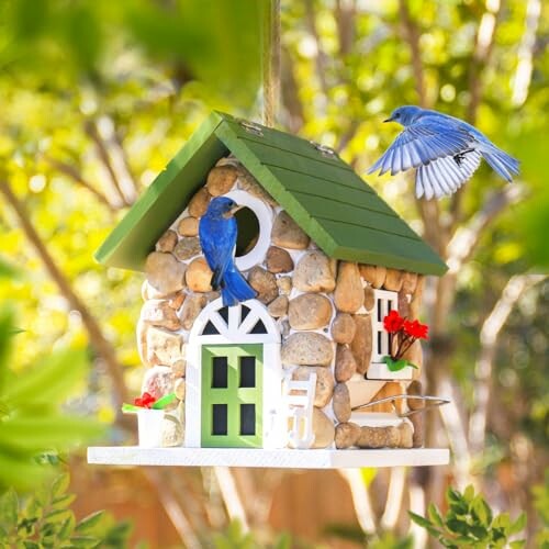 Decorative birdhouse with bluebirds in a garden setting