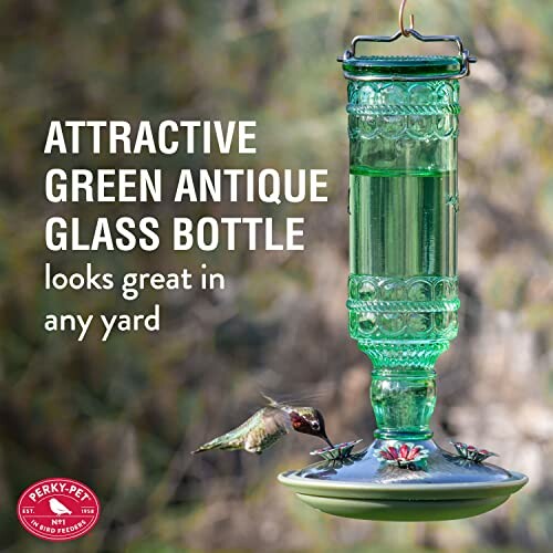 Green antique glass bottle bird feeder with hummingbirds.