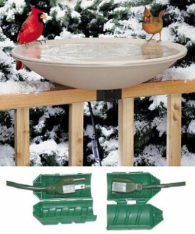 Heated bird bath with two birds in a snowy setting.