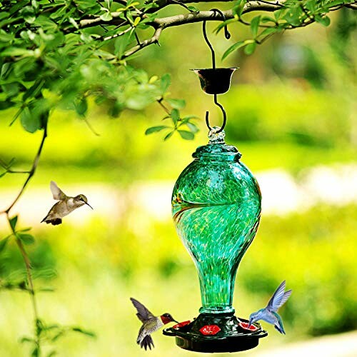 Colorful glass hummingbird feeder with three hummingbirds.