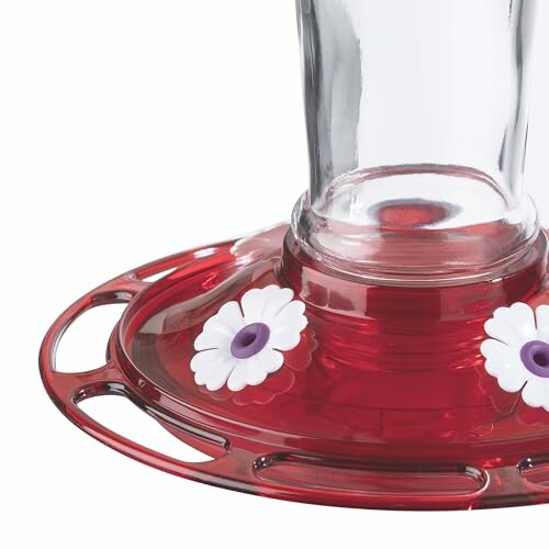 Red hummingbird feeder with white flower accents