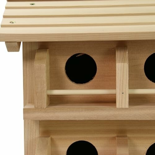 Side view of a wooden birdhouse with round entrances