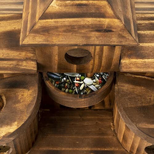 Wooden birdhouse containing assorted seeds.